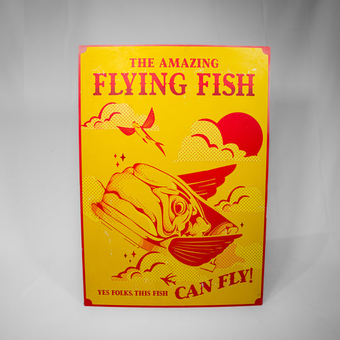 A portrait orientated poster of the Flying Fish coaster car. The main image is yellow and details and text are in red. It reads "The Amazing Flying Fish" at the top and "yes folks this fish can fly!" at the bottom