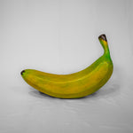 A 3D banana prop which is yellow with a brown tip.