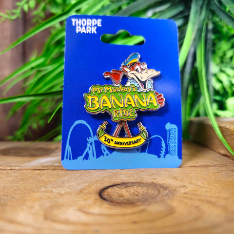 A pin badge with Mr Monkey's Banana Ride logo in the middle, Mr Monkey on top and a swinging Banana underneath with 30th Anniversary on it.