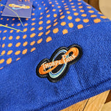 A close up of the embroidered logo. The main hat is blue with orange dots.