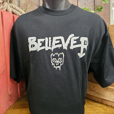 A black t-shirt with the word Believer in the middle. Underneath the word is a graffiti style skull with a cracked open cranium