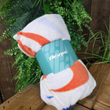 A white blanket with coloured details wrapped up in a roll with a belly band on it with the Thorpe Park logo