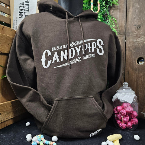 A chocolate brown hoody with a texture printed logo across the middle in a cream colour which reads 'Candypips' in a vintage style font. Above that in a smaller font size is 'Big Easy Blvd' and underneath is 'Sweeteasy'. There is a small white Thorpe Park logo on the bottom left of the front pocket