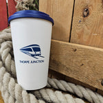 A white coffee tumbler with the Thorpe Junction logo on the back