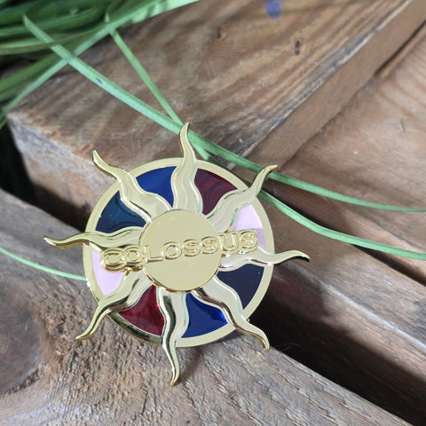 A round magnet with a sunbeam shape and Colossus logo