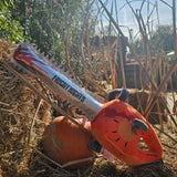 A photograph of a soft toy chainsaw, the blade is on the left in a silver fabric with a blood splatter and "Fright Nights" printed on it. The handle is a bridge orange with mechanical detailing