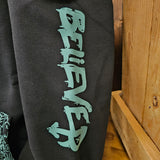 A close up of the word Believer printed on the arm