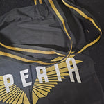 A closer look at the straps of the bag, which are woven black with a gold stripe through the middle.
