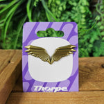 A pin badge, it is a set of metal wings in a brushed bronze colour. 