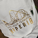 A white sweatshirt, with a gold foil print saying Find Your Fearless and Hyperia underneath. Above the text is the coaster skyline.