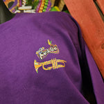 A purple sweatshirt, close up on the logo and trumpet detail