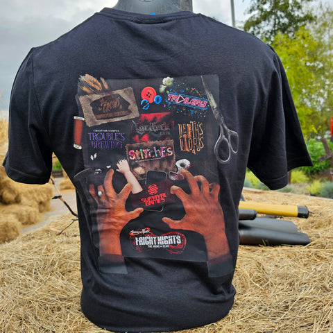 The back of a black t-shirt, with a graphic printed on it showing the maze logos. At the bottom are the hands of an old lady reaching upwards