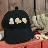  black cap with three pieces of popcorn embroidered onto the front. They are white, with a lighter yellow border