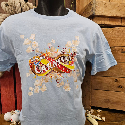 A powder blue t-shirt with an image of the carnival logo in the middle. Behind the logo is a top down view of a bucket of popcorn which has exploded throwing popcorn out of it across the t-shirt