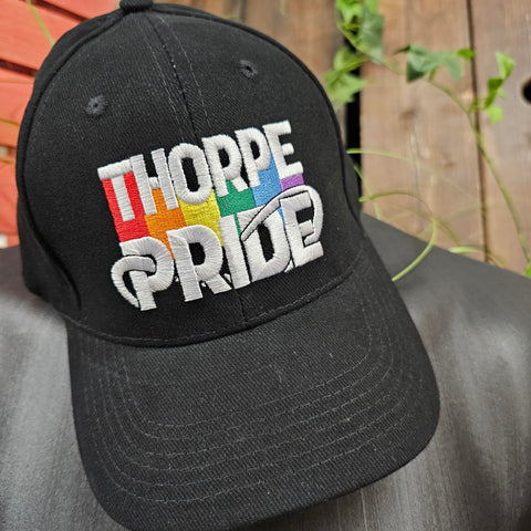 A black cap with the embroidered Thorpe Pride logo