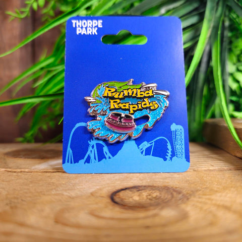 A pin badge with the Rumba Rapids logo, glittery water and a purple rapids boat which can slide along the base of the pin