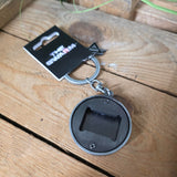 Reverse of the keychain with bottle opener on a wooden surface