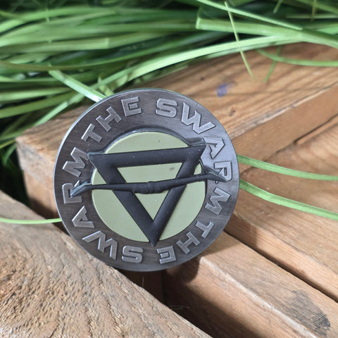 Round metal magnet with a rubberised SWARM symbol in the middle (which spins)