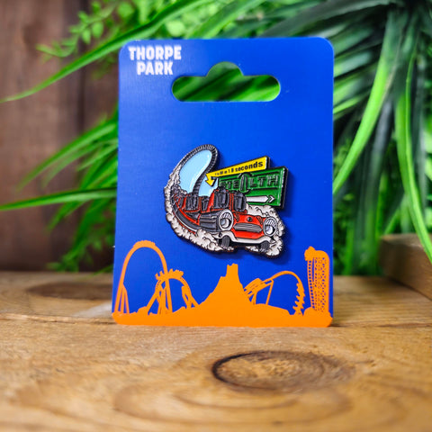 A cartoon style pin badge showing the Stealth car racing past the sign