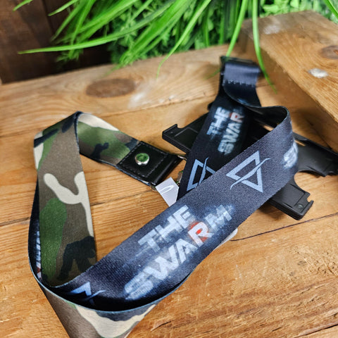 A lanyard with camo print on one side, and a grey background on the other complete with THE SWARM logo
