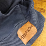 A close up of the faux leather label stitched to the hem of the hoody