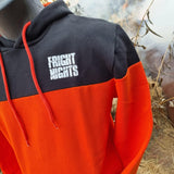 A photograph of the hoody, it is black across the top (to around the middle of the chest, then a hot orange colour below. There is a white Fright Nights logo printed on the chest area. The inner hood lining is the same orange, as are the toggles.