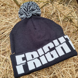 A photograph of a beanie hat with a black base and the word Fright Nights written around the base. On top is a white and black pom pom.