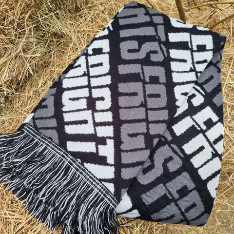 A photograph of the scarf, it is black with grey and white wording saying Fright Nights across it.