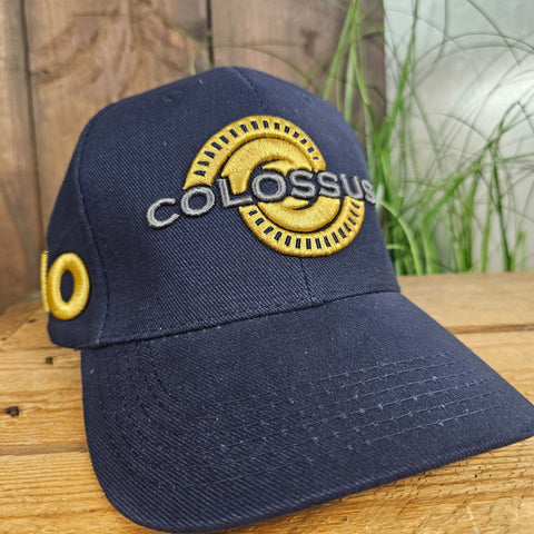 A navy blue cap with cold and silver embroidered Colossus logo on the front