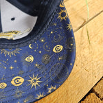 Underneath the peak of the cap, showing the all over print of astrological designs