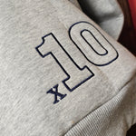 A close up of the embroidered x10 logo on the back of the hoody