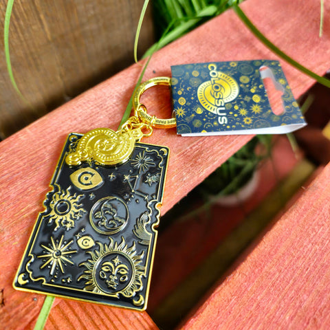 A photo of the keyring, the main keyring is a rectangle with gold star symbols and borders, infilled with a dark blue resin. On top is the Colossus logo as a gold charm.
