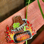 A magnet of the Nemesis Inferno volcano, with flames on the left and right hand sides. At the bottom is the Nemesis Infenro logo, and above is a silver train which can slide up and down the track.