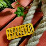 A magnet, it is a rectangle with rounded corners, with a deep yellow colour and glitter speckles to make it look slightly orange. The words Nemesis Inferno 20 are in the middle in black text
