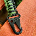 A photo of the woven green and black cord, and clip at the bottom