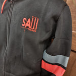 A photograph showing a close up of the embroidered red SAW - The Ride logo and grey and red stripes on the sleeves