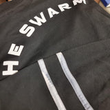 A photo showing the text on the back of the jersey, it is white and reads "The Swarm" (although in this image the "t" is covered by a sleeve).