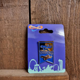 A photograph of the pin badge. It is square with the words Thorpe Park across the middle. The top half is silver with a blue Thorpe Park logo and the bottom half is blue with a silver Thorpe Park logo